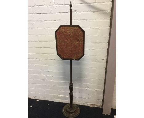 A nineteenth century mahogany firescreen with octagonal tapestry panel on turned pole and column raised on circular weighted 