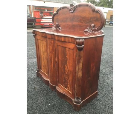 A Victorian mahogany chiffonier, having moulded scroll-carved back panel above a rectangular serpentine base with two panelle