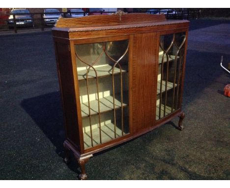 A mahogany bowfrounted china cabinet with rectangular moulded top above two astragal glazed doors flanking a central panel, r