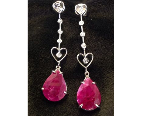 An 18ct pair of ruby & diamond drop earrings, the claw set pear shaped rubies beneath hearts and links mounted with diamonds,