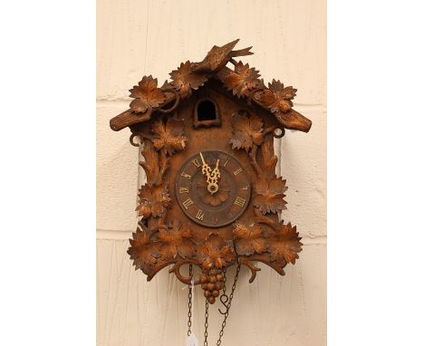 A late 19th Century Black Forest carved cuckoo clock, labelled to the back with J Faller, with two weights