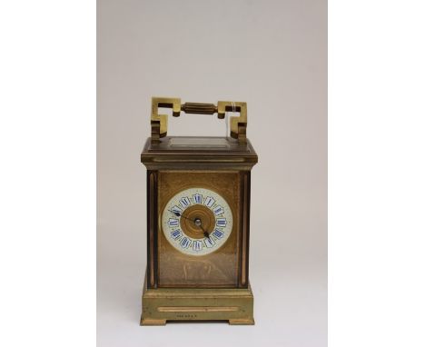 A French late 19th Century gilt brass carriage clock, enamel dial with blue Roman numerals, the front profusely engraved with