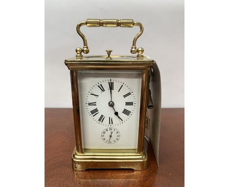 A late 19th/early 20th century French brass repeater carriage clock, white enamel dial with Roman numerals, subsidiary dial