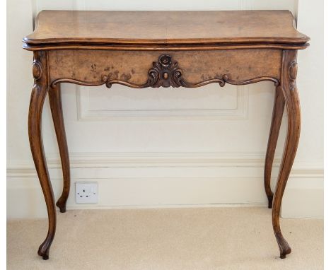 A Victorian walnut fold-over card table, circa 1870, the quarter-veneered serpentine moulded top opening and rotating, inset 