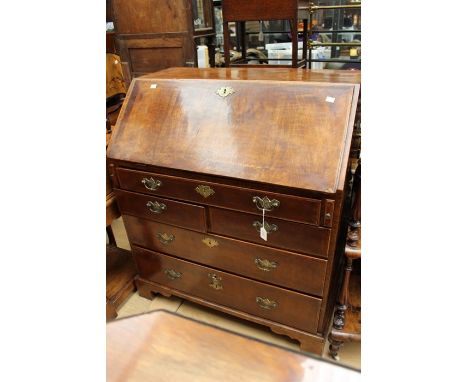A George I and later walnut bureau, circa 1720, the fall front enclosing drawers, a central door, pigeon holes and a secret d