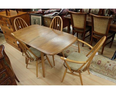 A set of Ercol elm seated and beech stick back chairs, hooped back rails, splayed legs, each marked to underside 'BS. HG 1960