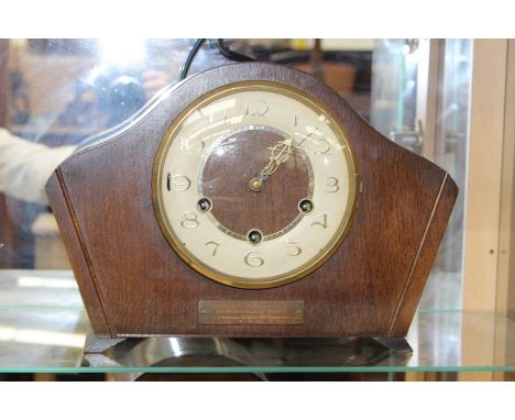 A 1950's Smiths oak cased eight day mantel clock, with a Westminster chime, with presentation plaque dated 1957