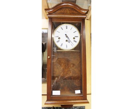 A Comitti mahogany cased eight day wall clock, having a jingle glazed door, white enamelled dial and three winder holes, West