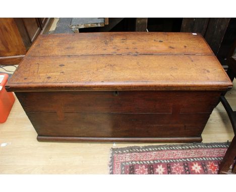 An early 19th Century mahogany travelling trunk, plank lid enclosing large storage section, carrying handles to each side, 52