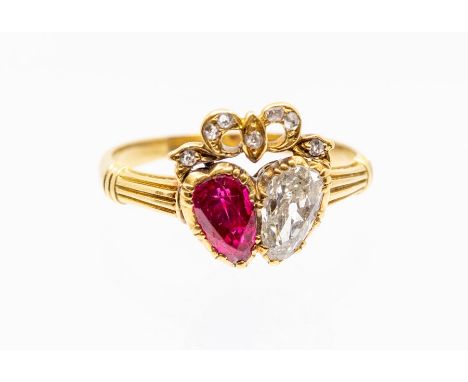 A Victorian double heart ring, comprising a claw set pear cut ruby and diamond with diamond set bow top, the ruby weighing ap