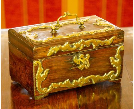An 18th Century brass mounted oak casket or caddy, of rectangular outline, the hinged top with scroll handle opening to a two
