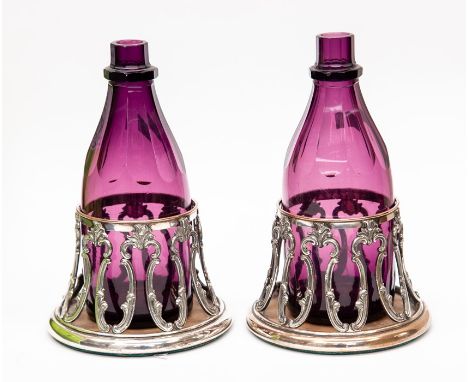 A pair of early 19th century amethyst glass decanters, stoppers lacking, in original silver plated coasters, circa 1835/40, a