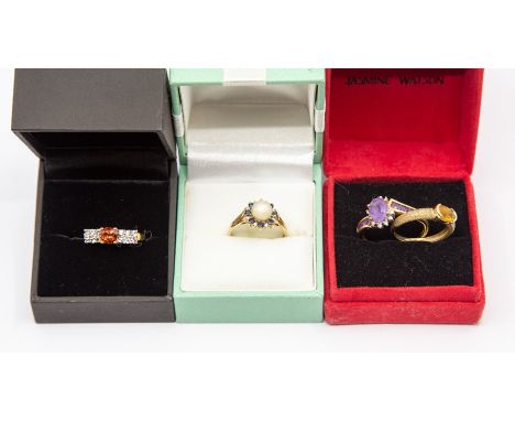 A collection of four 9ct gold dress rings to include an amethyst and diamond cross over ring, size T, a citrine ring with ova