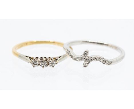 A diamond and 18ct white gold cross over ring, size R, along with a diamond three stone 18ct gold&nbsp; ring, comprising thre