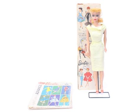 Barbie: A boxed, circa 1950's, Barbie Doll, wearing earrings and in yellow shift dress with a bow, in original box (with some