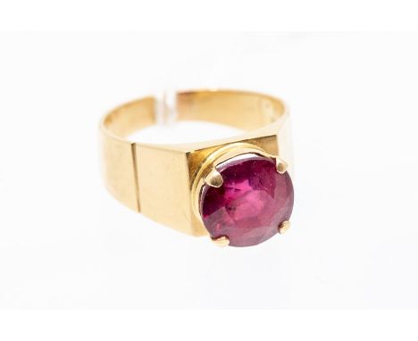 A ruby and 18ct gold dress ring, the round cut ruby approx 10mm x 10.3mm x 7.3mm, claw set to an angular mount with engraved 