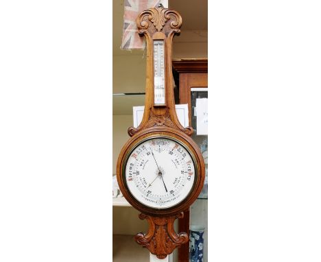 A late Victorian oak wall hanging banjo shaped aneroid barometer and thermometer