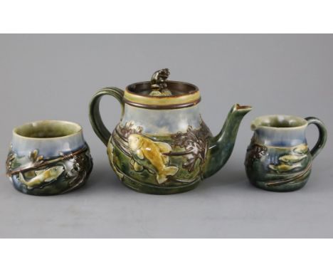 A Royal Doulton 'fish and pond weed' three-piece tea set, designed by George Tinworth, made c.1905, the teapot with seated fr