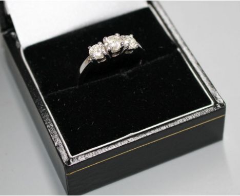 A modern 14k white metal and three stone diamond ring, with a total approximate carat weight of 0.85cts, size O, gross 3.6 gr