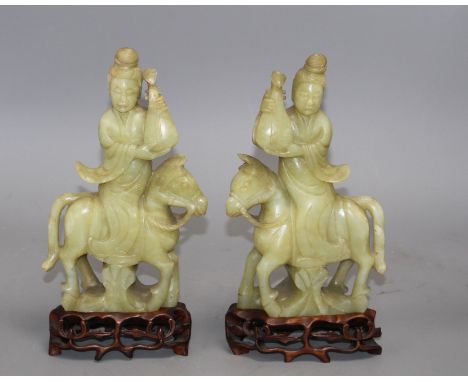 A pair of Chinese bowenite jade groups of a lady riding a horse, wood stands natural inclusions and veining to the stone, in 