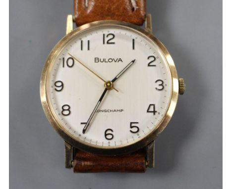 A gentleman's 9ct gold Bulova Longchamp manual wind wrist watch, on associated strap. Condition: Gross weight 34.8 grams. Cas