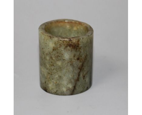 A Chinese celadon and brown jade cylinder, probably archaic, natural inclusions in the stone, possibly re-shaped at one end, 