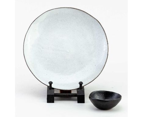 KAORI TATEBAYASHI (born 1972); a stoneware plate covered in pitted pale grey glaze with manganese rim, impressed K and Japane