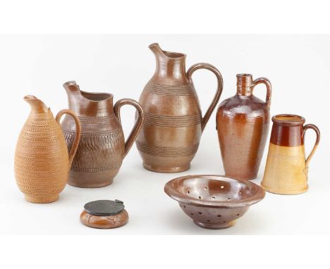A collection of late 19th/early 20th century salt glazed pieces including three jugs with sgraffito type decoration, tallest 