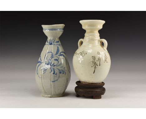 20th century AD. A pair of glazed ceramic vases comprising: one blue-glazed frond detailing, facetted body and eccentric mout