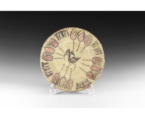 19th-early 20th century AD. A ceramic plate in early style, with Kufic inscription between plant motifs; to the centre bird w