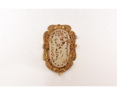 An undated archaistic ellipsoid openwork glass(?) plaque of a dragon and a fenghuang bird on a frame of brass filigree with f