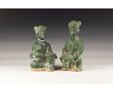 20th century AD. A pair of ceramic green glazed statuettes of females seated, flowers to the hair with bows to the side; lose