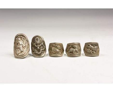 20th century AD. A mixed group of silver-coloured metal finger rings, three with advancing lion motif; two with lobed plaque.