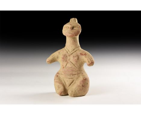 An undated archaistic ceramic idol with incised lines to the body, discoid face with spike to the rear.   437 grams, 16.5cm (