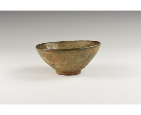Song Dynasty, 960-1127 AD. A conical ceramic bowl covered in a mottled dark glaze once streaked with fine russet-coloured 'ha