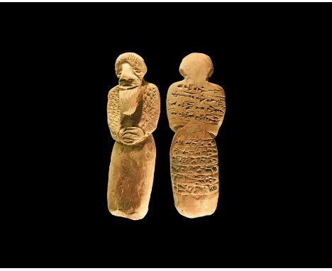 An undated archaistic ceramic figurine of a robed and bearded male with hands clasped at the waist, bands of pseudo cuneiform