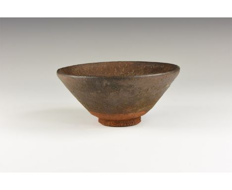 Song Dynasty, 960-1127 AD. A conical ceramic bowl covered in a mottled dark glaze once streaked with fine russet-coloured 'ha