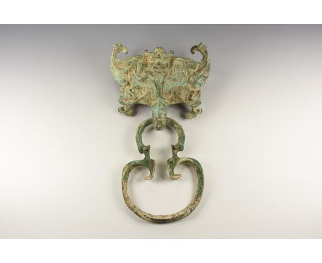 A large bronze undated archaistic door knocker with an upper section formed as a dragon head with male mask to the top.   1.2