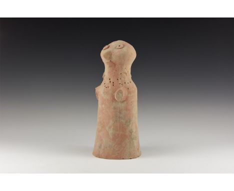 3rd-2nd millennium BC. A ceramic figure of a bird-head divinity with bell-shaped robe, applied pellet eyes, pointillé rosette