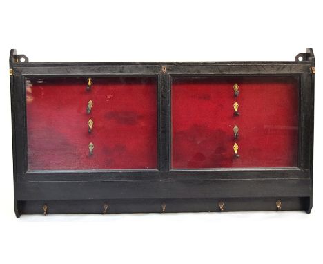 A Victorian black painted glazed gun display wall hanging cabinet, with hooks mounted beneath for cartridge belts, dog leads 