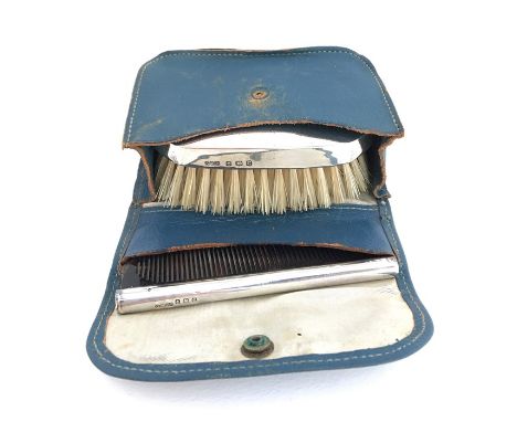 A silver topped hairbrush, monogrammed EK, and silver topped comb, Birmingham, 1902, in blue leather case