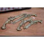 Four brass wall decorations in the form of flintlock pistols