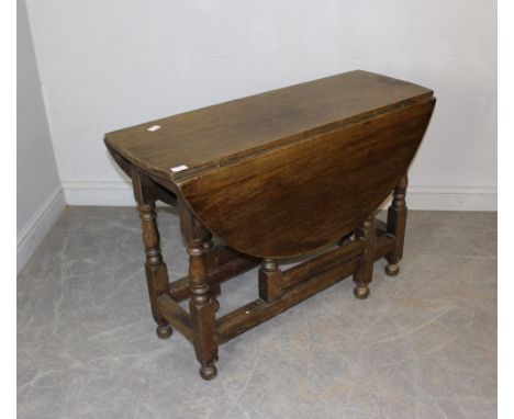 An oak drop-leaf gate-legged table, with demi-lune flaps and turned supports 74cm x 107cm x 39cm minor marks, scratches wear 