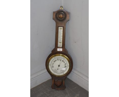 A mid 20th century oak wheel or banjo barometer, with thermometer scale and silvered dial, by R Clark Newcastle-On-Tyne 66cm 