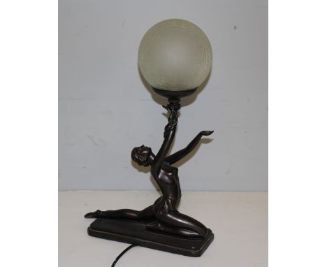 A modern figural electric table lamp, in The Art Deco style, with semi-nude female figure holding a spherical crackled glass 