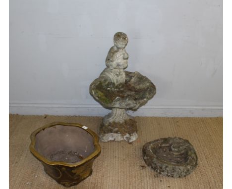 A cast composite stone bird bath, with figural flute player surmount over the scallop shell form top and fluted column and sc