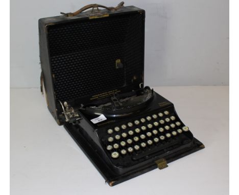 A vintage Remington Home Portable Typewriter, wear to cloth covered case.