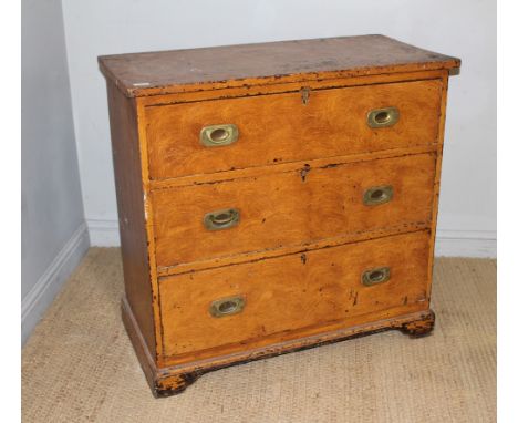 A 19th century scumbled-pine chest of three drawers, each drawer with rounded rectangular brass back-plates and flush handles