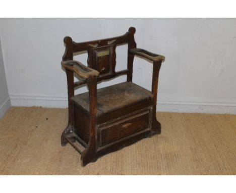 An Arts and Crafts style oak hall seat, the shaped and pierced back with central panel bearing a presentation plaque  'to Ali