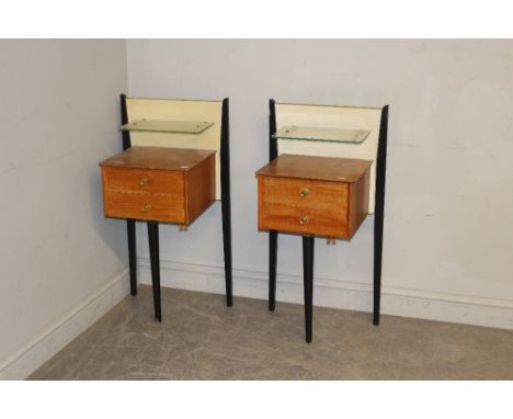 A apir of 1960's oak and ebonised bedside tables, the raised backs with glass shelf over two drawers and three tapering eboni